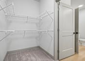 Thumbnail 47 of 59 - A white closet with a toilet in the background.