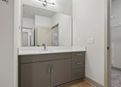 Thumbnail 31 of 59 - A bathroom with a sink, mirror, and cabinets.