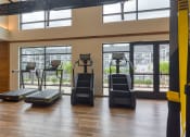 Thumbnail 62 of 81 - a gym with cardio equipment and windows in a building at Ainsworth, Richmond