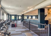 Thumbnail 11 of 35 - a fitness room with cardio machines and chairs at the bottom of a staircase