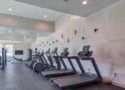 Thumbnail 15 of 53 - a gym with cardio equipment and weights in a building with windowsat Blue Ridge Commons Apartments, Roanoke, Virginia
