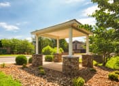 Thumbnail 17 of 21 - a covered porch with stone pillars on the side of a road