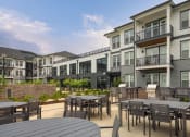 Thumbnail 11 of 81 - an outdoor patio with tables and chairs at an apartment complex at Ainsworth, Richmond, Virginia