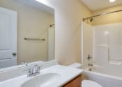 Thumbnail 12 of 21 - a bathroom with a white tub and a sink and a mirror