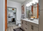 Thumbnail 10 of 38 - a bathroom with a large mirror and a sink and a toilet at Aura Stonebridge, Virginia
