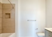 Thumbnail 34 of 47 - a bathroom with a sink and a toilet and a shower at The Port at East Beach Apartments and Marina, Virginia
