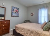 Thumbnail 20 of 44 - A bedroom with a bed, dresser, and a painting on the wall.