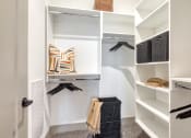 Thumbnail 11 of 38 - a walk in closet with white walls and shelves and a closet organizer with black glovesat Aura Stonebridge, Richmond, 23225