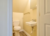 Thumbnail 18 of 26 - A white toilet sits next to a white sink in a small bathroom.