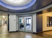 Thumbnail 56 of 60 - a hallway with doors and a blue ceiling light at Proximity at ODU, Norfolk