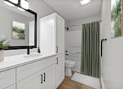 Thumbnail 27 of 67 - A white bathroom with a green shower curtain.