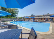 Thumbnail 18 of 32 - our resort style swimming pool is surrounded by chairs and umbrellas