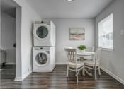 Thumbnail 9 of 32 - a laundry room with a washing machine and a table with chairs