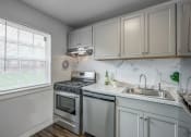 Thumbnail 1 of 32 - an all white kitchen with stainless steel appliances and a window