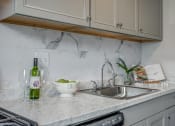 Thumbnail 2 of 32 - a kitchen counter with a sink and a bottle of wine on it