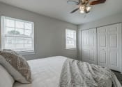 Thumbnail 12 of 32 - a bedroom with a large bed and a ceiling fan