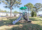 Thumbnail 2 of 22 - A playground with a green slide and a red slide.