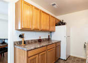 Thumbnail 15 of 22 - A kitchen with wooden cabinets and a white refrigerator.
