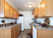 Thumbnail 14 of 22 - A kitchen with wooden cabinets and a granite countertop.