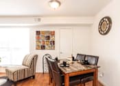 Thumbnail 13 of 22 - A dining room with a table set for two and a clock on the wall.