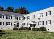 Thumbnail 18 of 19 - A white building with black shutters and a black lamp post.