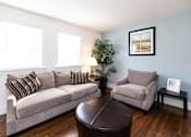 Thumbnail 3 of 19 - A living room with a couch, chair, and table.