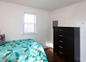 Thumbnail 9 of 19 - A room with a bed and a dresser.