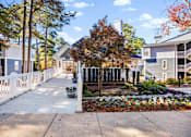 Thumbnail 28 of 34 - A white picket fence leads to a building with a sign that reads "1101.".
