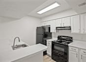 Thumbnail 19 of 29 - A kitchen with white cabinets and appliances.