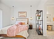 Thumbnail 21 of 29 - A bedroom with a bed, a shelf, and a lamp.