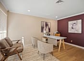 Thumbnail 2 of 29 - A living room with a brown chair, a grey chair, and a white table.