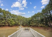 Thumbnail 56 of 57 - a bridge over a body of water with a bench on it at Shellbrook, Raleigh, North Carolina
