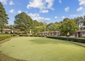 Thumbnail 55 of 57 - a putting green with apartments in the background at Shellbrook, Raleigh, NC
