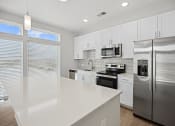 Thumbnail 12 of 47 - Experience culinary bliss in our newly custom-built kitchens featuring expansive quartz counter island and space filled with natural lighting at Centro at Pine Nash, Wilson, NC, 27893