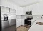 Thumbnail 29 of 47 - Featured B1 Floor Plan Kitchen designed with energy efficient appliances and quartz countertops Centro at Pine Nash, Wilson, NC