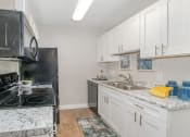 Thumbnail 8 of 43 - a kitchen with white cabinets and a stove and a sink at Village 1373, North Carolina