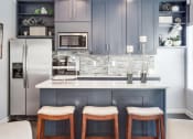 Thumbnail 32 of 35 - a kitchen with a counter and three bar stools  at Midtown Crossing, Raleigh