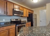 Thumbnail 1 of 21 - a kitchen with granite counter tops and wooden cabinets