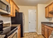 Thumbnail 2 of 21 - a kitchen with granite counter tops and wooden cabinets