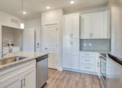 Thumbnail 14 of 42 - a kitchen with white cabinets and granite counter tops and a sink at The Bella at Westchester, Midlothian, VA, 23113