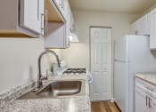 Thumbnail 17 of 24 - a kitchen with white cabinets and a sink and a refrigerator at Gates of West Bay in Norfolk, VA 