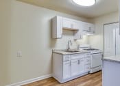 Thumbnail 20 of 24 - an empty kitchen with white cabinets and a white stove and refrigerator at Gates of West Bay in Norfolk, Virginia