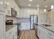 Thumbnail 2 of 40 - a kitchen with marble counter tops and white cabinets at The Walker Virginia Center, Glen Allen, VA