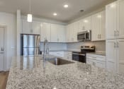 Thumbnail 13 of 40 - an open kitchen with granite counter tops and white cabinets at The Walker Virginia Center, Glen Allen, Virginia