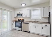 Thumbnail 1 of 36 - a kitchen with white cabinets and a sliding glass door