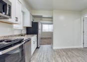 Thumbnail 2 of 36 - an empty kitchen with white cabinets and stainless steel appliances