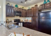 Thumbnail 34 of 60 - a kitchen with black appliances and granite counter tops at Proximity at ODU, Virginia, 23508