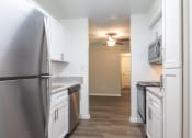 Thumbnail 18 of 39 - an empty kitchen with stainless steel appliances and a ceiling fan