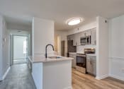 Thumbnail 8 of 56 - A kitchen with white cabinets and a white island with a black faucet.