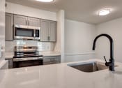 Thumbnail 10 of 56 - A modern kitchen with a stainless steel oven and microwave.